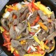 meat, peppers, and onions in a cast iron pot
