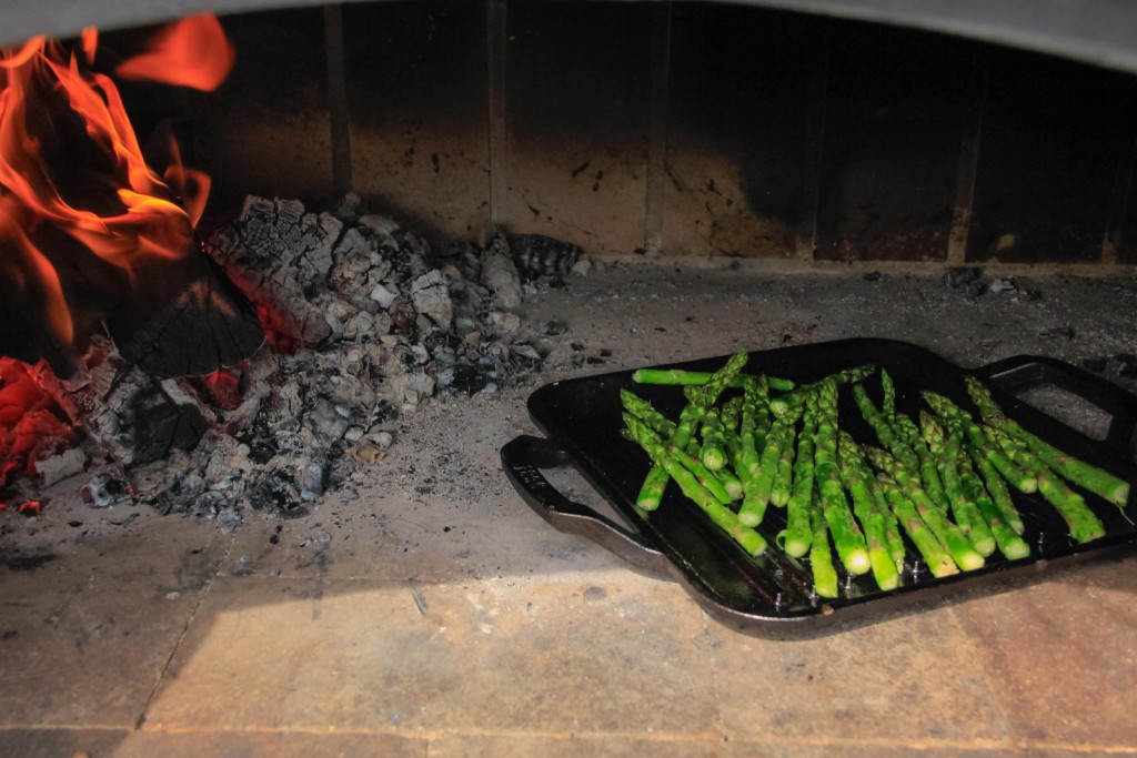 veggies on a pan in an outdoor brick oven